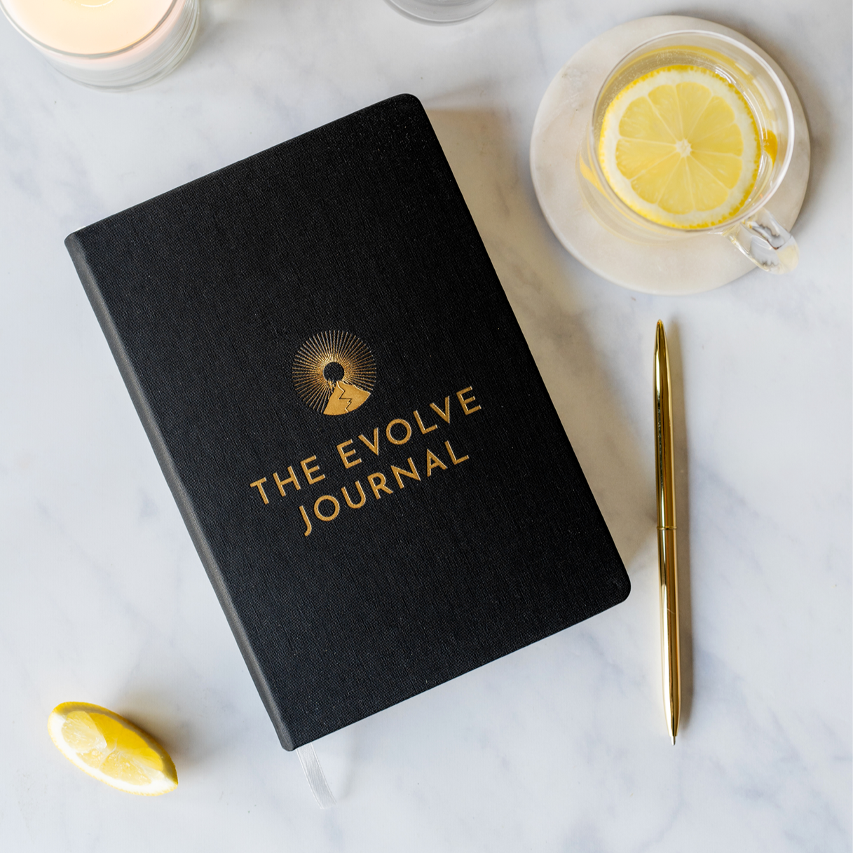 Black journal titled 'The Evolve Journal' with a gold pen beside it.